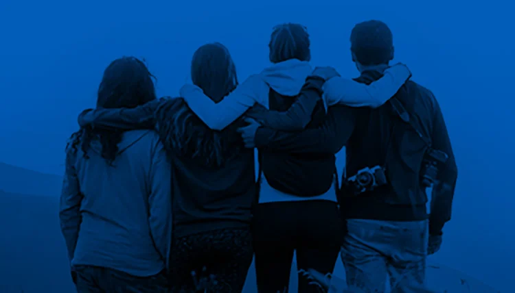 Four people living with narcolepsy with arms around each other looking into the distance